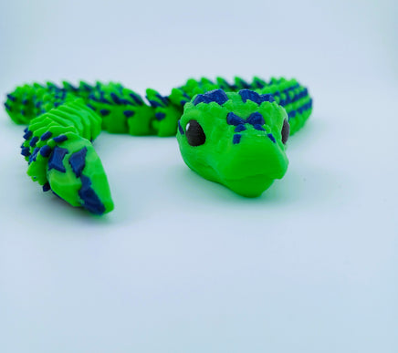 Green and blue textured toy on a light gray background